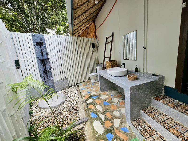 Jungle Haven's semi-covered open-air bathroom at DK2 Resort, with stone sink and rain shower