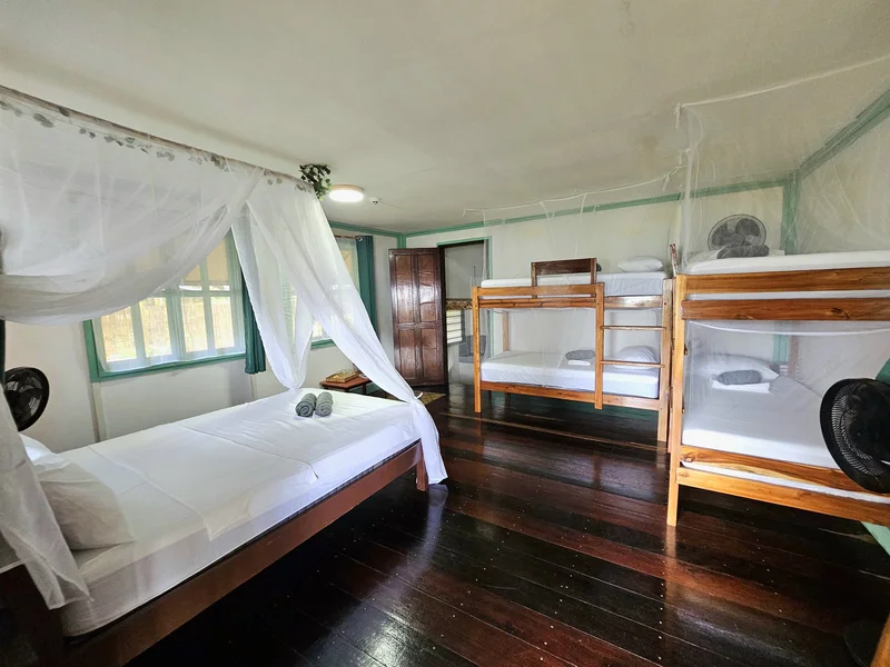 Inside the Palmscape bungalow at DK2 Resort: four single bunk beds and one canopy double bed with mosquito nets